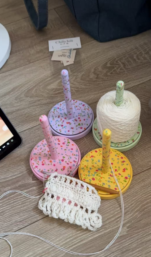 Cozy crochet station with floral yarn spool holders and cotton yarn