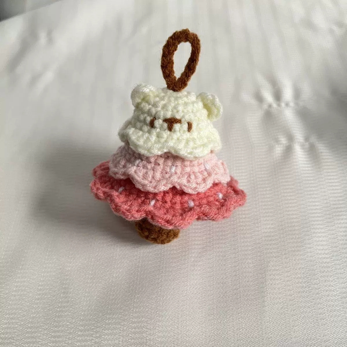 Pink handmade crochet charm with soft yarn layers