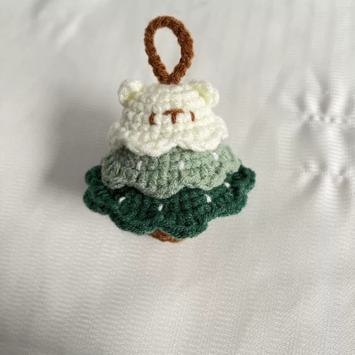 Green handmade crochet charm with soft yarn texture